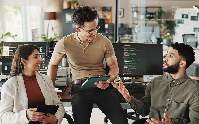 Personas sentadas en una mesa con equipos informáticos